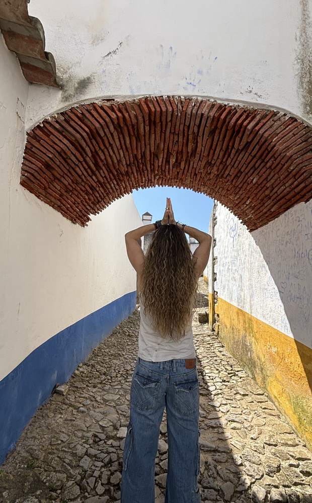 Lydia bajo un arco, con las manos en oración
